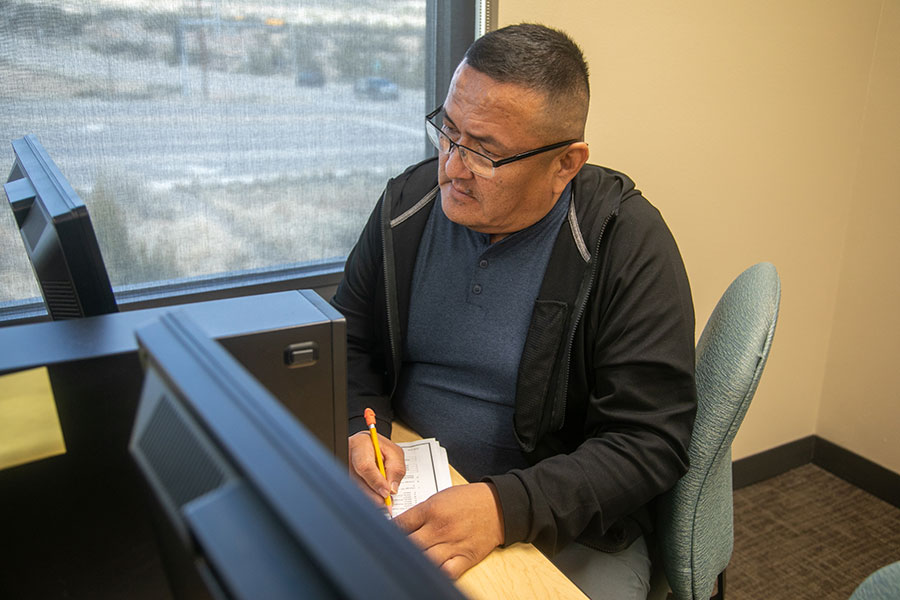 Adult student at San Juan College in front of computer.