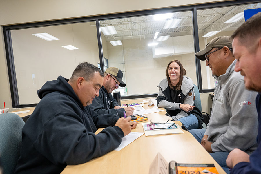 Adult learners meeting with an advisor at a community college to plan a career change using transferable skills and new training opportunities