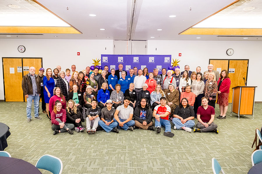 All of the SJC Foundation Scholarship recipients huddles together in front of a SJC backdrop