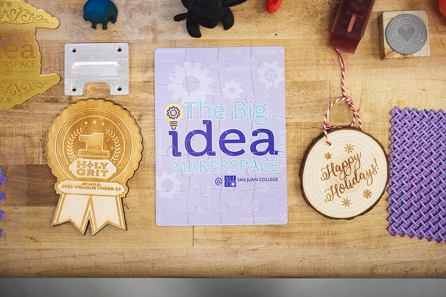 Pieces of laser engraved wood, a puzzle and an ornament made at the San Juan College The Big Idea Makerspace