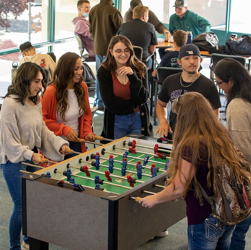 San Juan College students playing foosball in the Suns Student Lounge.