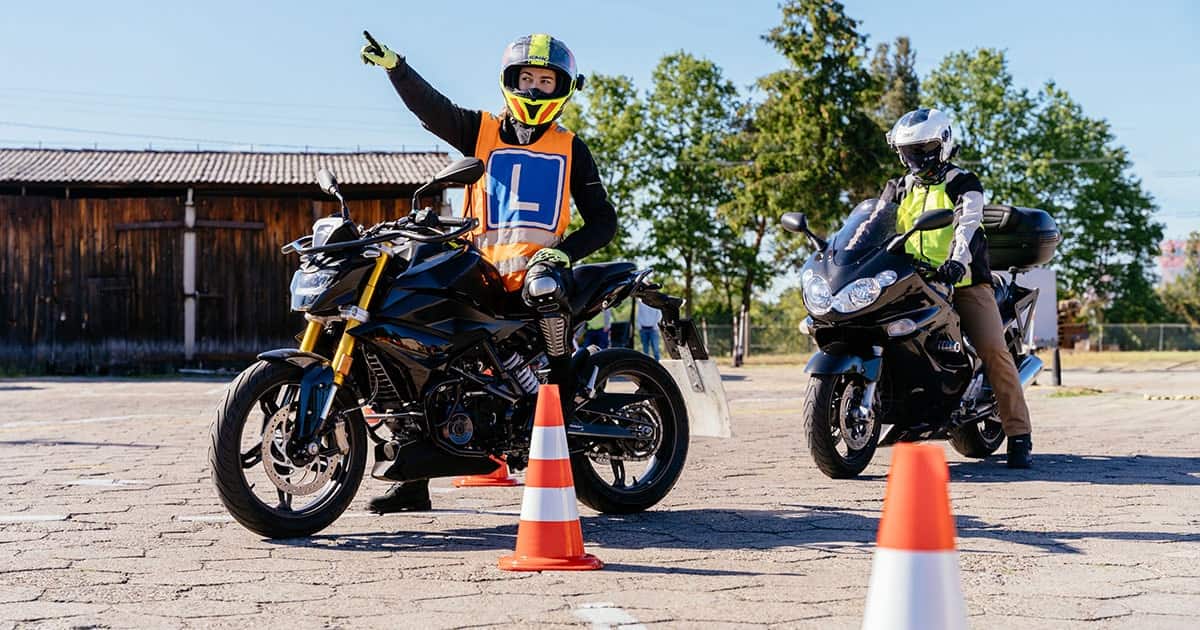 Students on motorcycles navigating through orange cones